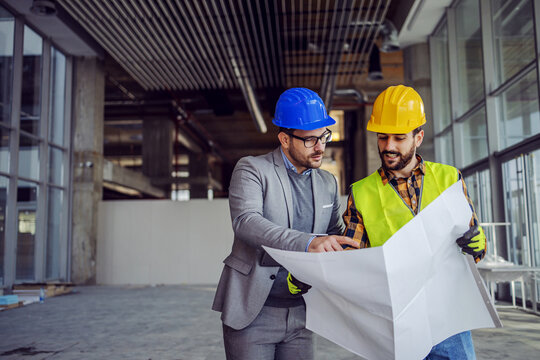 Project managers reviewing construction plans on site
