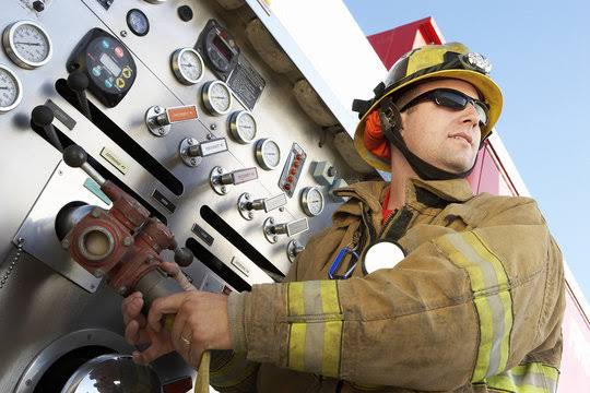 Firefighter operating fire truck control panel